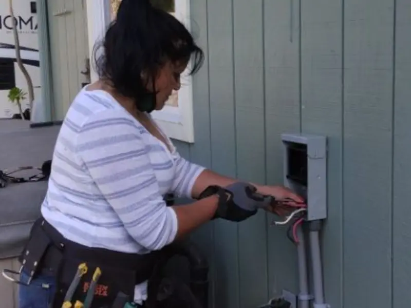 Licensed electrician wiring an exterior subpanel in Laconia